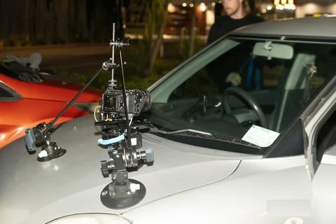 Setting up a camera on top of a tripod to keep it stable on a car. Stock-Fotos