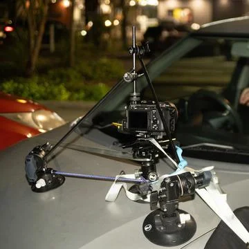 Setting up a camera on top of a tripod to keep it stable on a car. Stock Photos