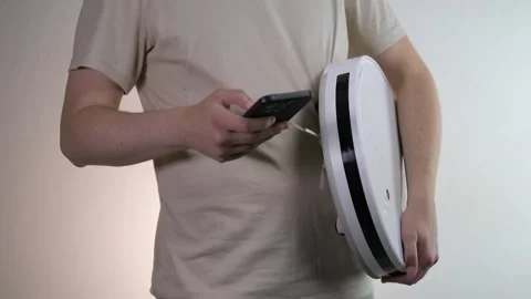 Setting up communication between the phone and the robot vacuum cleaner Stock Footage 313588491