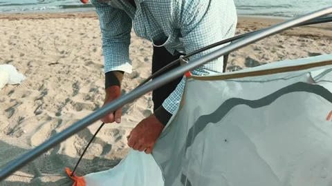 Setting Up a Cozy Tent Right on the Beautiful Beach for Outdoor Experience Stock Footage 281623286