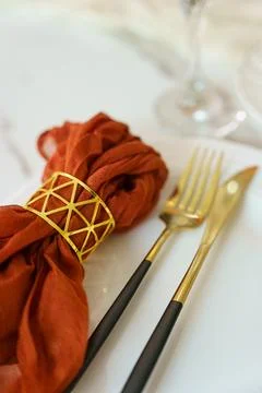 Setting a dining table with a cloth napkin, fork and knife placed neatly on.. Stock Photos