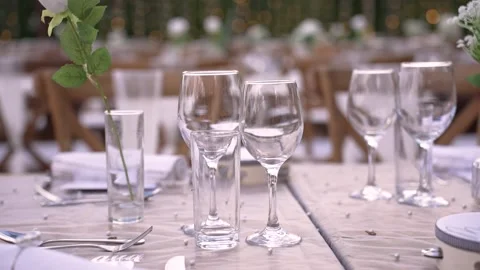 Setting a dining table for a wedding event in an outdoor location with elegant Stock Footage 335912704