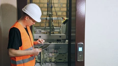 Setting up the elevator operating program using a digital tablet, elevator Stock Footage 262802125