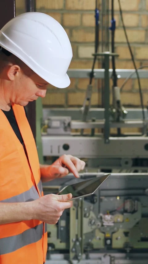 Setting up the elevator operating program using a digital tablet, elevator Stock Footage 300877832