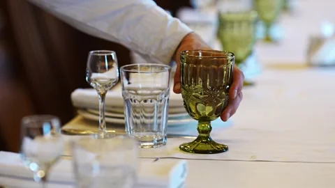 Setting a fine dining table with green glasses Stock Footage 320304389