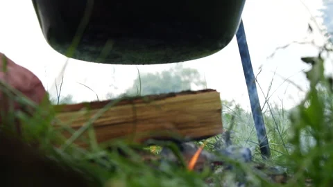Setting fire under the kettle outdoors Stock Footage 135608881