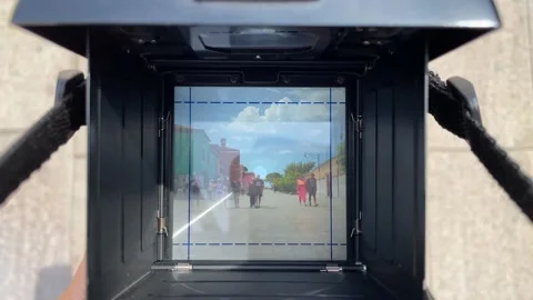 Setting up focus on the vintage camera screen while people walking towards it Stock Footage 204835006