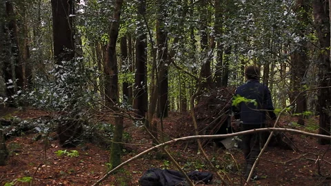 Setting up a handbuilt  shetler in a forest 2 Stock Footage 236712039