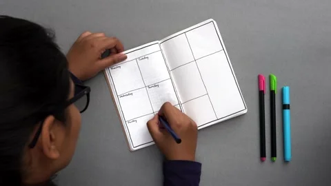 Setting up a journal by making columns for the days of the week Stock Footage 147134979