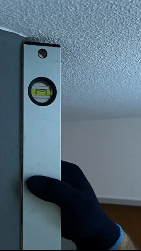 Setting a level tool on the wall to ensure straight alignment in a room during h Stock Footage 328939367