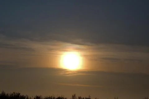 The setting low sun among the clouds. 스톡 사진