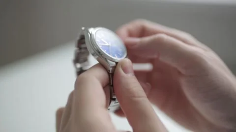 Setting the metal clock on time. Hands in macro shooting and steel watch. Stock Footage 105724271