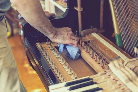 Setting up an old piano. The master repairs an old piano. Deep cleaning the p Stock Photos