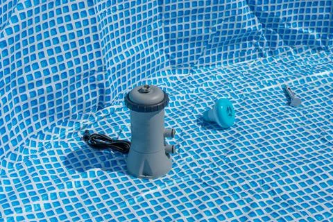 Setting up a pool with pump and accessories on a blue and white patterned Foto stock