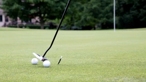 Setting up to putt golf ball on a golf green Stock Footage 124825727