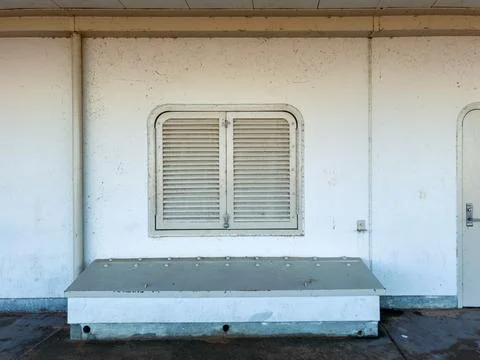 The setting shows a flat gray platform against a plain wall with a closed win Stock Photos