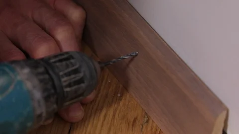Setting up a skirting with a self-tapping screw Stock Footage 122208125