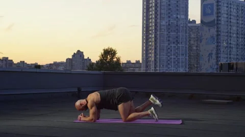 In the setting sun, the athlete performs an exercise on the muscles of the legs. Stock Footage 254472376