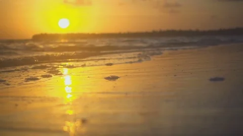 Setting sun on the beach among the waves Video stock 72150922