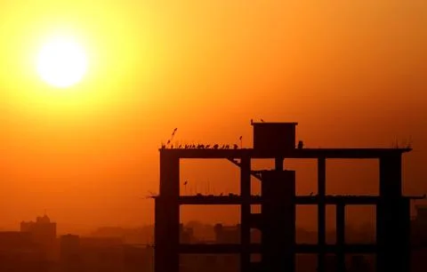 Setting sun behind construction building Stock Photos