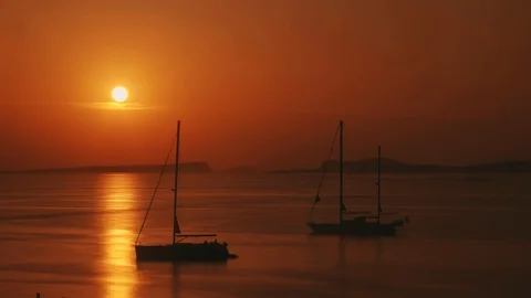 Setting sun behind the island mountains with sailboats Stock Footage 123090148