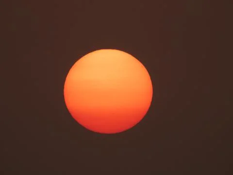 The setting sun disk with visible sunspots. Taken on October 27, 2020 Stock Photos
