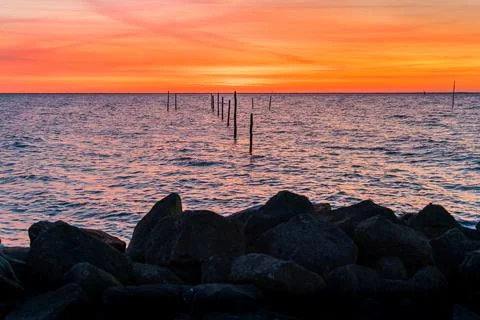 Setting sun with fish trap at the coast Stock Photos