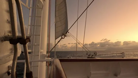 Setting sun give warm glow to sailing ship structure at sea Stock Footage 232950443