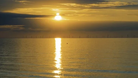 The setting sun glows a bright orange on the sea surface Stock Footage 94617404