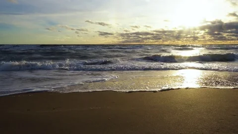 The setting sun illuminates the sandy shore Stock Footage 82171479