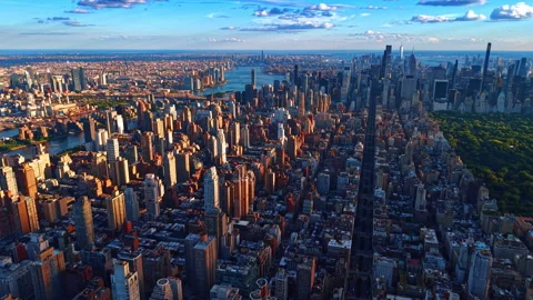 Setting sun lights the buildings at the waterfronts of the East River. Flight Stock Footage 336897027