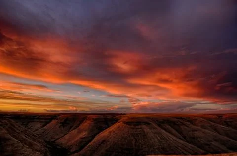 The setting sun makes the clouds glow orange over a canyon in Idaho Foto stock