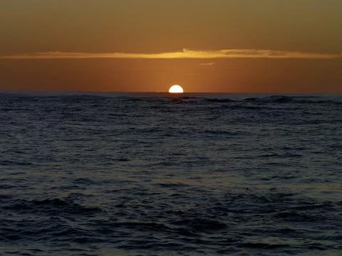 SETTING SUN WITH ORANGE SKY AND BLUE OCEAN Foto stock