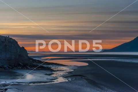 The setting sun over Alaskas Cook Inlet on a summer evening in South-central Al Stock Photos