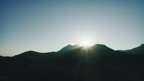 Setting sun over black silhouette of mountain. Drone aerial shot. Stock Footage 217405676