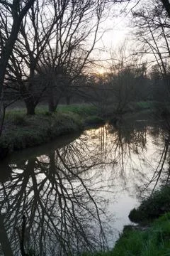 Setting sun over a river, reflections in water 스톡 사진