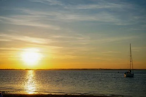 Setting sun over a sandy beach in the South of England 库存照片