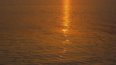 The setting sun is reflected in the lake. The bright orange sun is reflected in Video stock 212437348