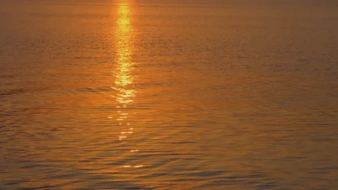 The setting sun is reflected in the lake. The bright orange sun is reflected in Stock Footage 230529038