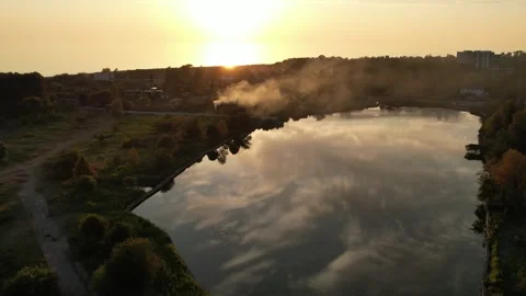 The setting sun is reflected in the lake, the yellow sunset shines black smoke 库存影片 256599735