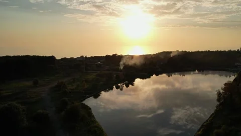 The setting sun is reflected in the lake, the yellow sunset shines black smoke 库存影片 256599931