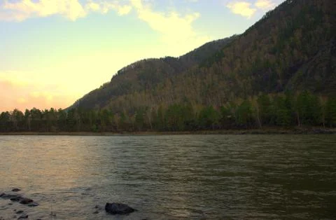 The setting sun is reflected in the turquoise waters of the Katun. Altai, Sib Stock Photos