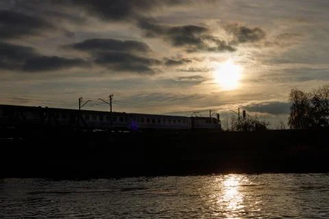 The setting sun is reflected in the waters of the river . Stock Photos