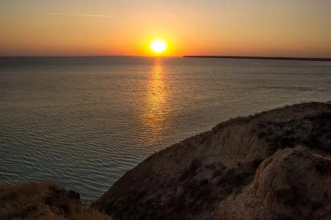 Setting Sun Reflecting on Water with Calm Ocean Waves Stock Photos