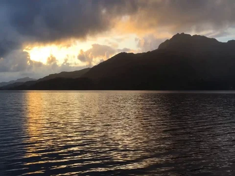 Setting sun reflects off the rippling waters of Scottish Loch (4K) Stock-Footage 79884897