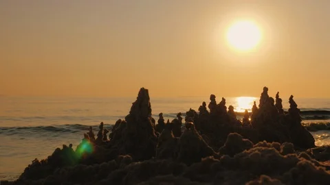 The setting sun shines on the sand castle on the seashore Stock Footage 104105352