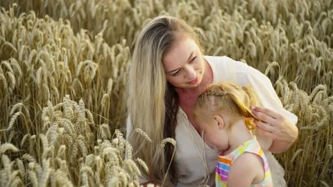 The setting sun shines on their faces as mother and daughter enjoy time together Stock Footage 252064907