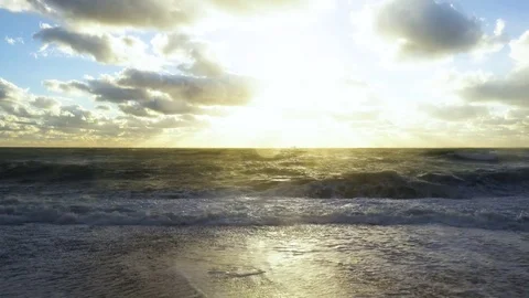 The setting sun shines through the clouds to the stormy sea Stock Footage 82171068