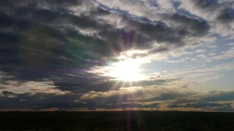 The setting sun shines through dark clouds on the Mongolian steppe. Stock Footage 281729742