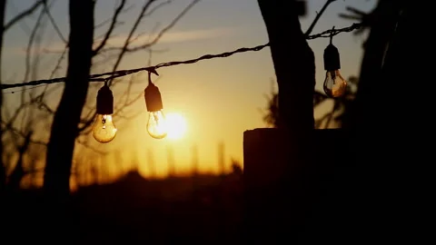 The setting sun shines through a light bulb. Stock Footage 124456213